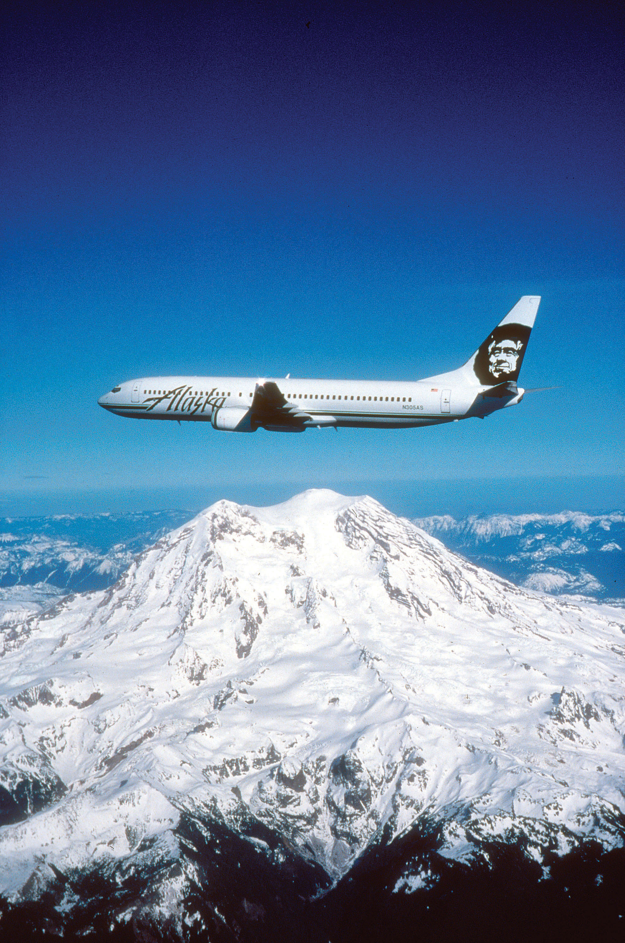 Alaska Airlines plane flies over a mountain