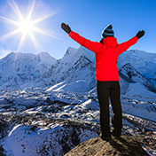 person on top of a mountain with their hands in the air