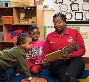 Jacqualine Boles, director of family and health services at Tiny Tots, reading a book to kids