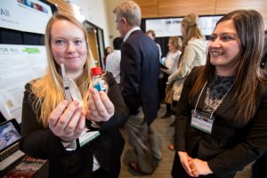 Emily Willard (left) and Katherine Brandenstein (right) display the prototype for the SafeShot, a device to sterilize needles and prevent the spread of bloodborne pathogens.
