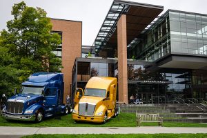 PACCAR trucks in front of PACCAR hall