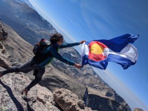 Aaron kennedy waving flag on mountain