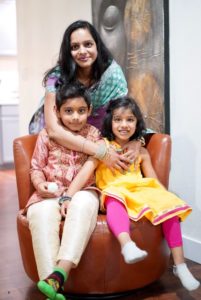 Ashima Jain posing with her children, looking into the camera and smiling