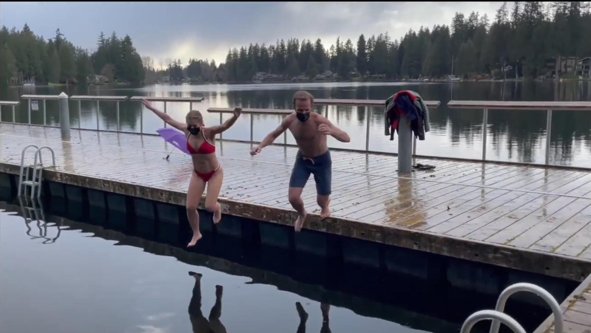 mba students jumping off of a dock into lake washington