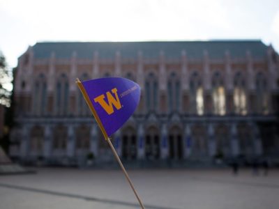 a uw penant flag held aloft in front of suzzalo library