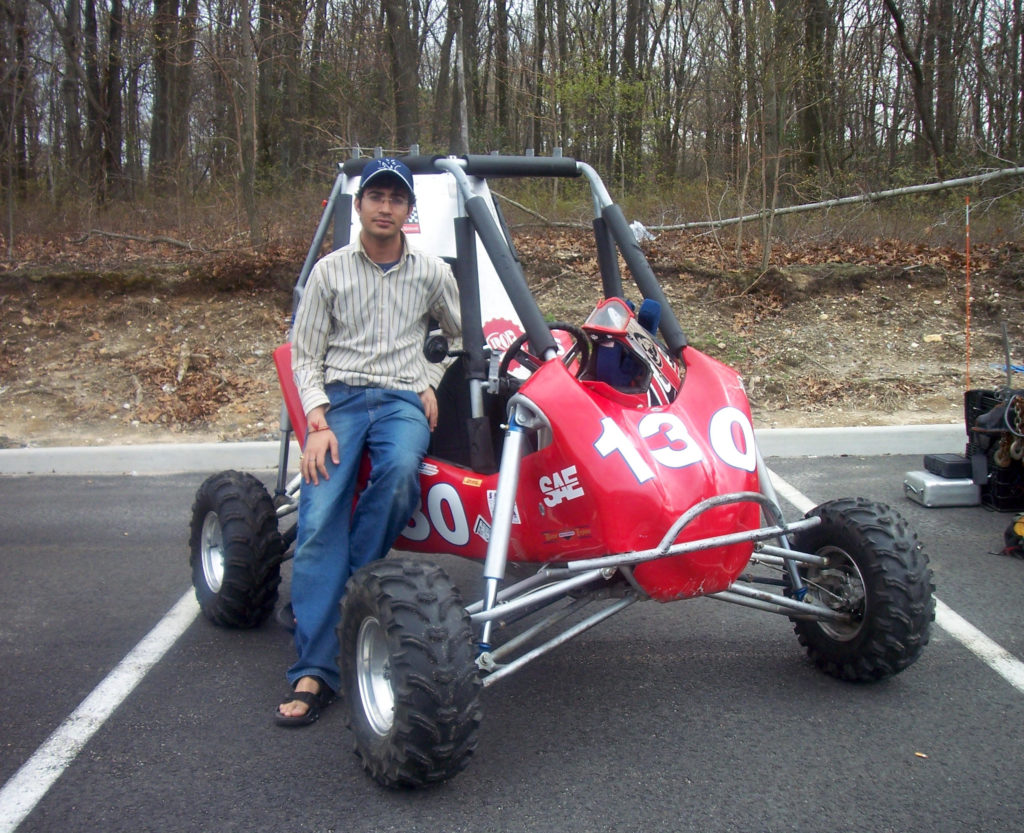 Man standing next to red go-kart.