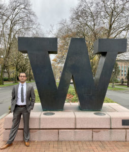 Man standing in front of big W statue on campus.