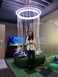 Kristen standing under "the jellyfish", which was designed to support neurodiverse employees
